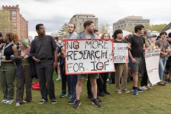 A pro-Palestine protester holds a placard that says, "No more research for IOF (Israeli Occupation Forces)" during a 2024 rally 